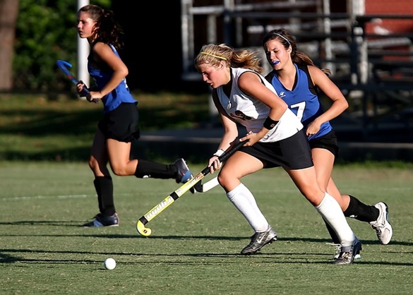 Hóquei esportivo e mulher em ação no campo com taco de hóquei pronto para  bater a bola no jogo exercício de fitness e atleta feminina jogando hóquei  em campo no estádio ao